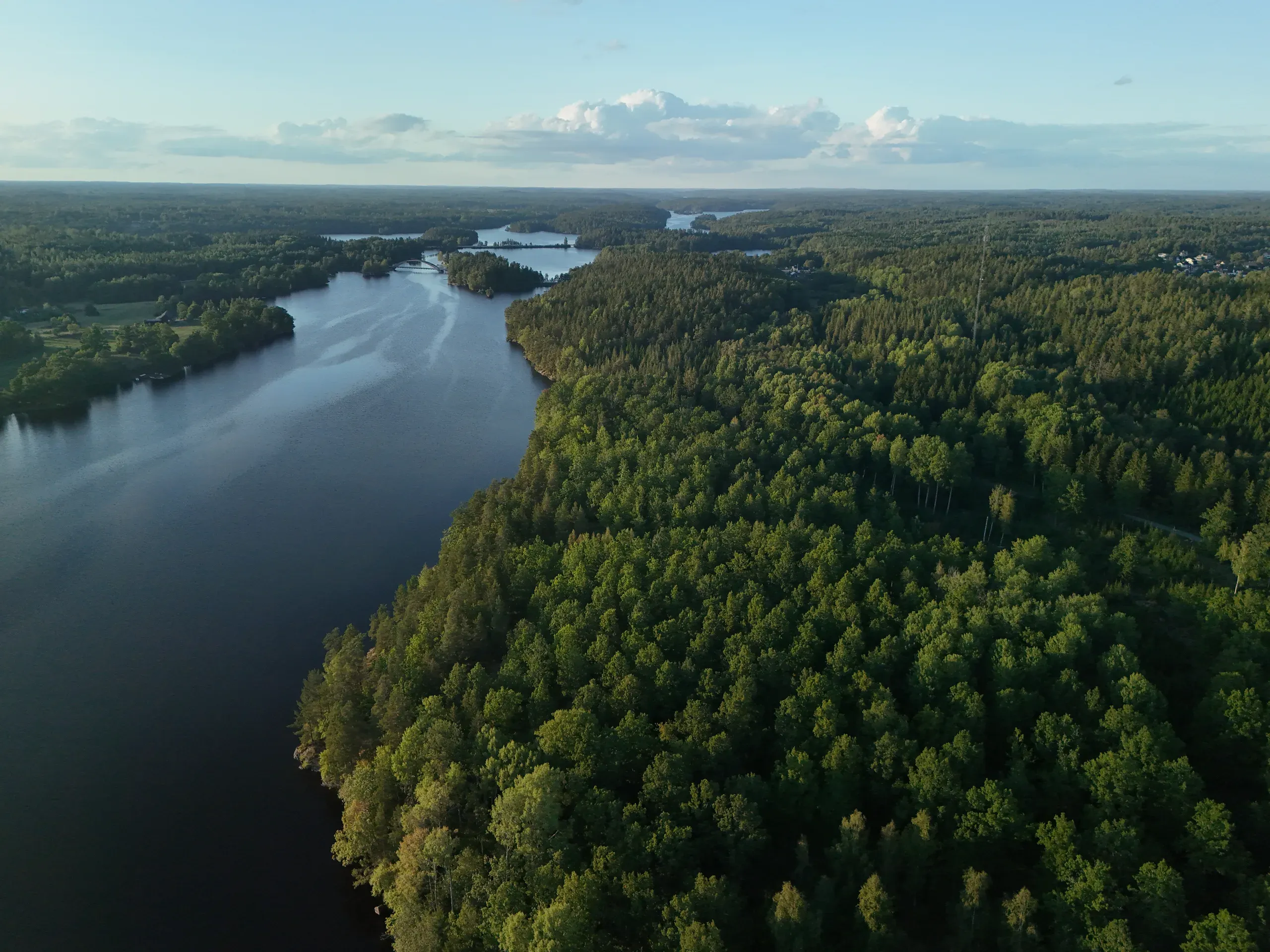 Flygbild över Långsjön omgiven av vidsträckta skogar i Småland, Sverige